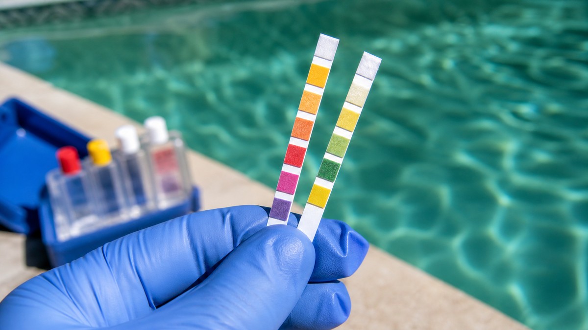 Tiras de análisis de agua de piscina mostrando pH y cloro durante un tratamiento de choque